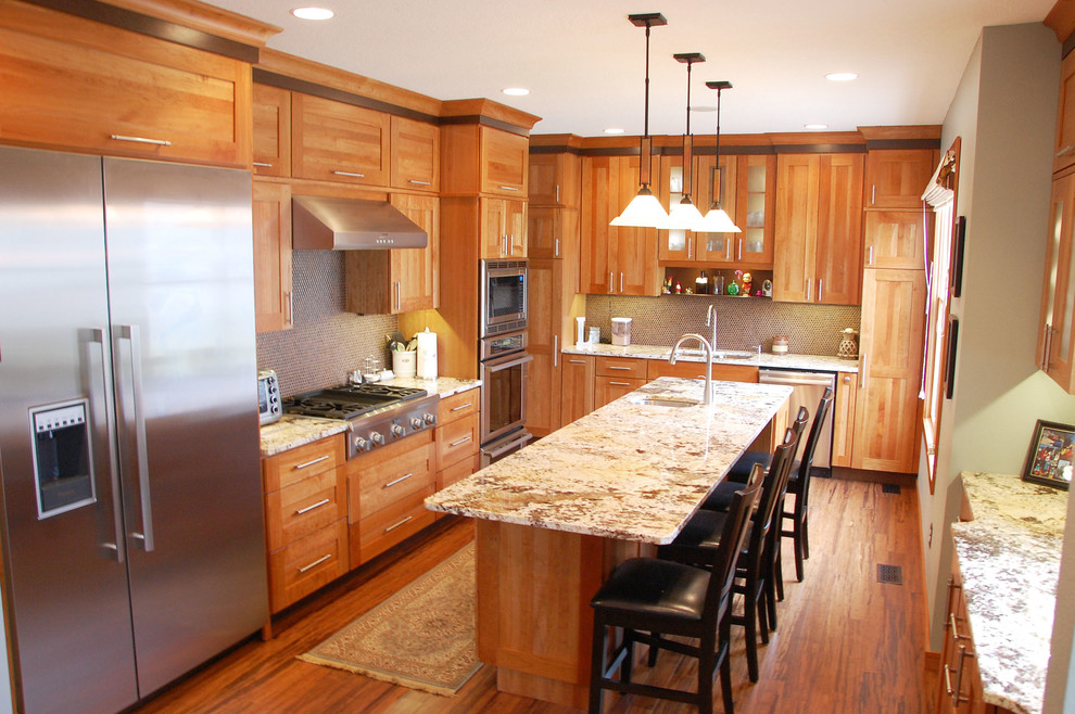 Modern inredning av ett mellanstort l-kök, med en undermonterad diskho, skåp i mellenmörkt trä, granitbänkskiva, stänkskydd med metallisk yta, stänkskydd i mosaik, rostfria vitvaror, mellanmörkt trägolv, en köksö och skåp i shakerstil