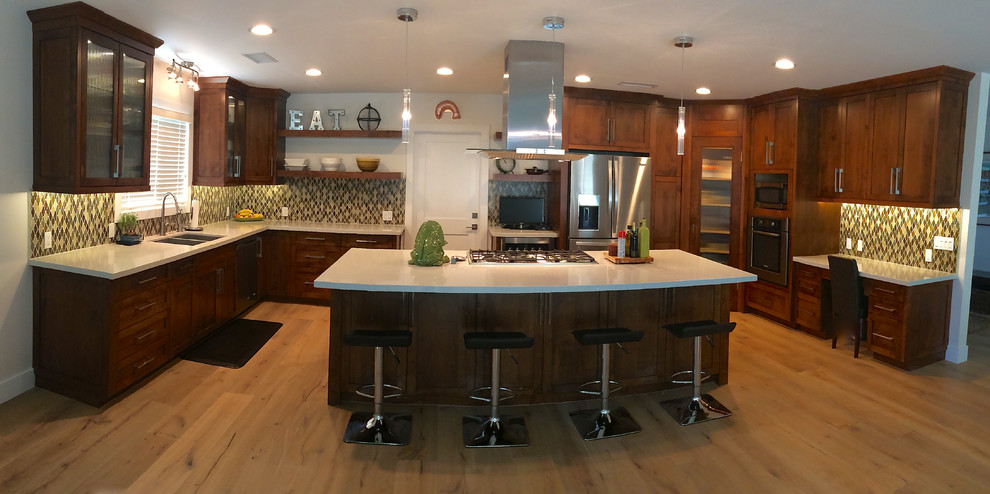This is an example of a large contemporary u-shaped enclosed kitchen in Orange County with shaker cabinets and an island.
