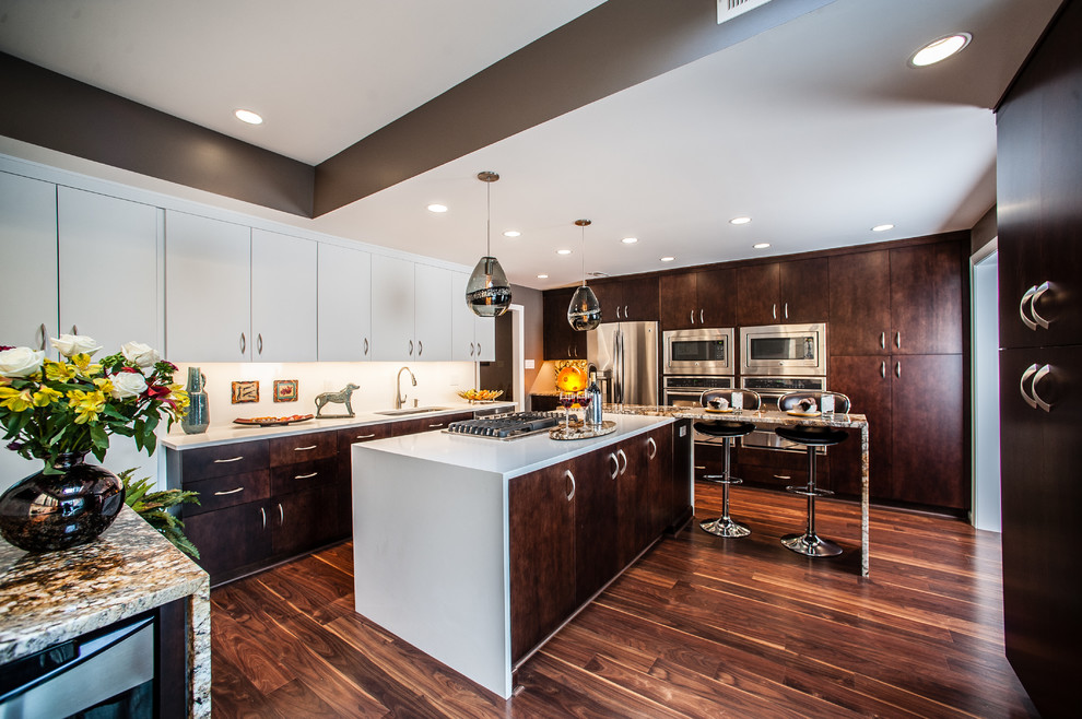 Kitchen - mid-sized contemporary u-shaped medium tone wood floor, brown floor and tray ceiling kitchen idea in Baltimore with an undermount sink, flat-panel cabinets, dark wood cabinets, white backsplash, quartz backsplash and stainless steel appliances