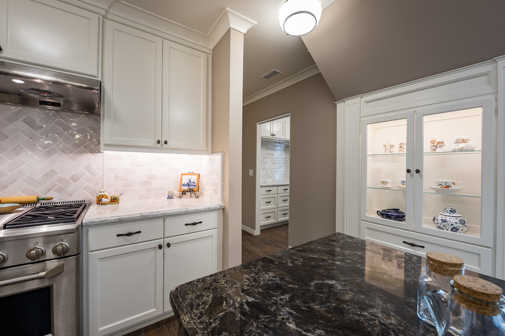 Example of a mid-sized trendy u-shaped dark wood floor and brown floor eat-in kitchen design in Other with a farmhouse sink, shaker cabinets, white cabinets, marble countertops, white backsplash, subway tile backsplash, stainless steel appliances, a peninsula and white countertops