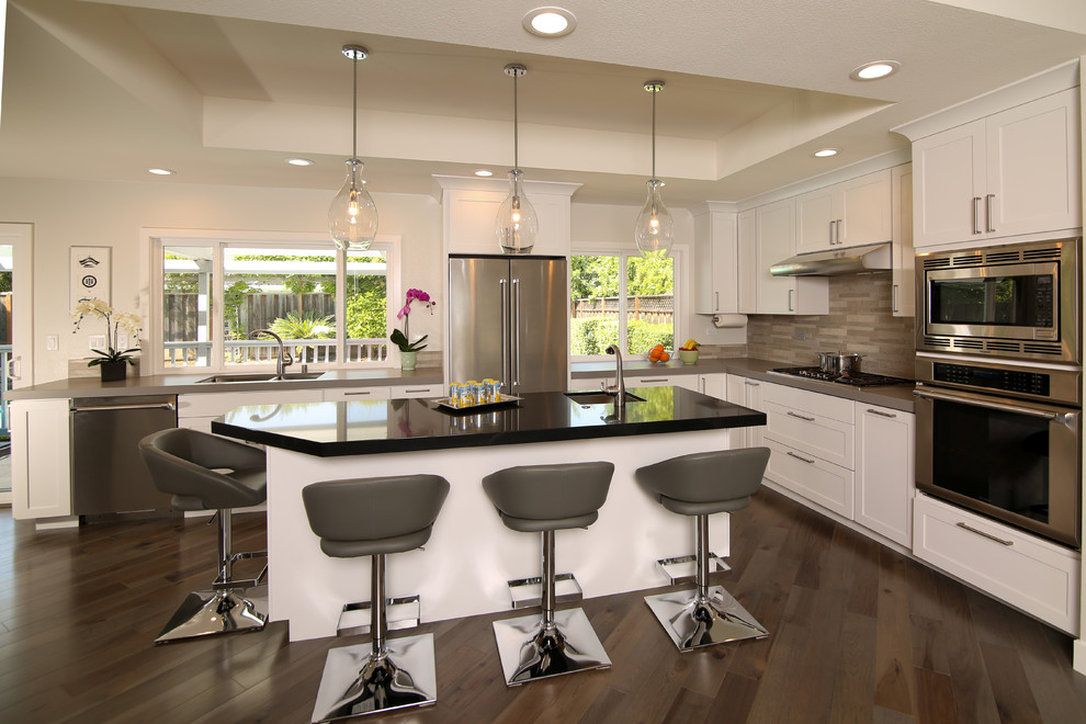 Eat-in kitchen - large contemporary l-shaped dark wood floor, brown floor and tray ceiling eat-in kitchen idea in San Francisco with a double-bowl sink, shaker cabinets, white cabinets, matchstick tile backsplash, stainless steel appliances, an island, gray backsplash, gray countertops and quartz countertops