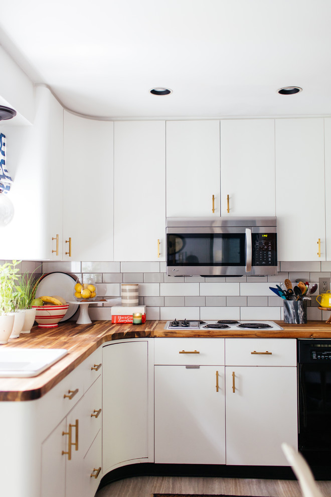 Exempel på ett avskilt, mellanstort modernt l-kök, med en nedsänkt diskho, släta luckor, vita skåp, träbänkskiva, vitt stänkskydd, stänkskydd i tunnelbanekakel, rostfria vitvaror, laminatgolv och grått golv