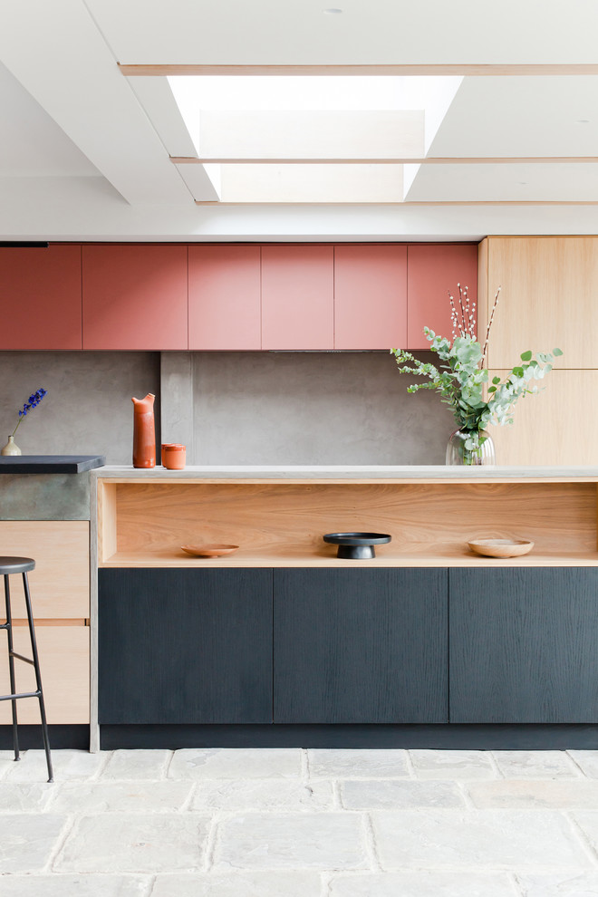 Moderne Küche mit flächenbündigen Schrankfronten, hellen Holzschränken, Küchenrückwand in Grau, Kücheninsel, grauem Boden und grauer Arbeitsplatte in Sonstige