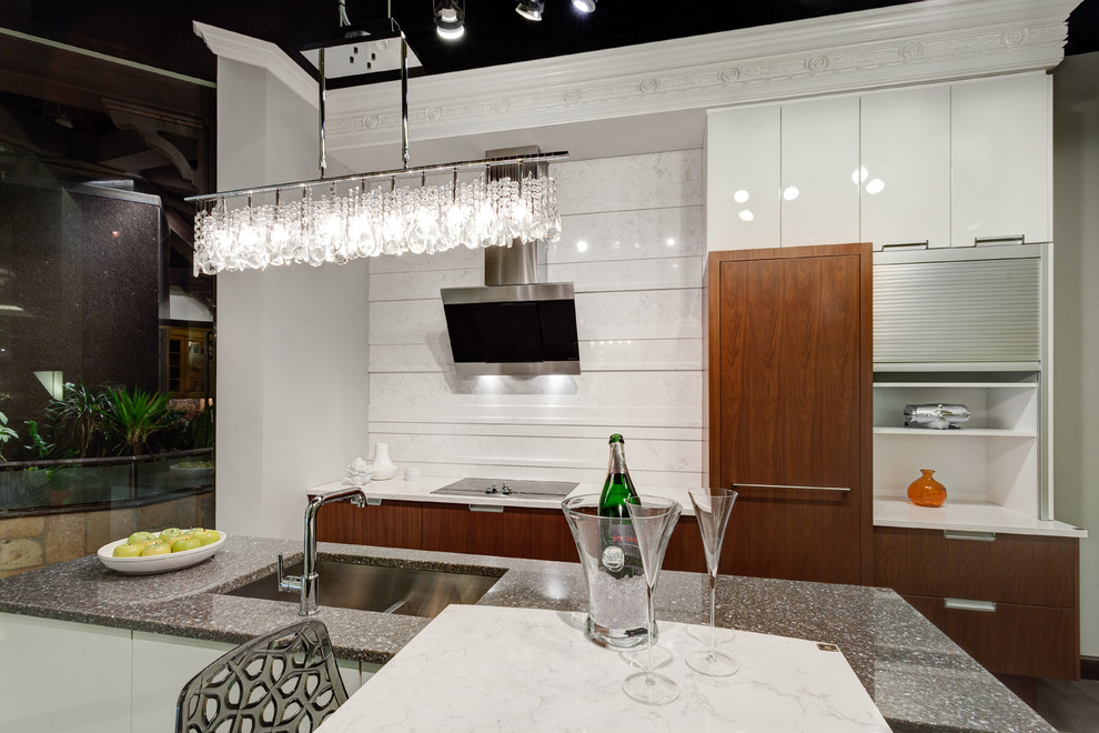 This is an example of a contemporary l-shaped kitchen/diner in Chicago with engineered stone countertops, stone slab splashback, a belfast sink, flat-panel cabinets, white cabinets, stainless steel appliances and an island.
