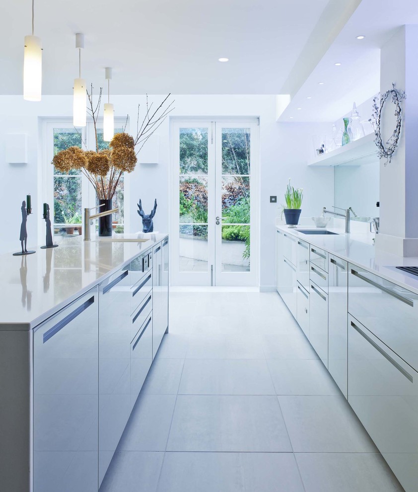 Идея дизайна: параллельная, глянцевая кухня в современном стиле с плоскими фасадами и серыми фасадами