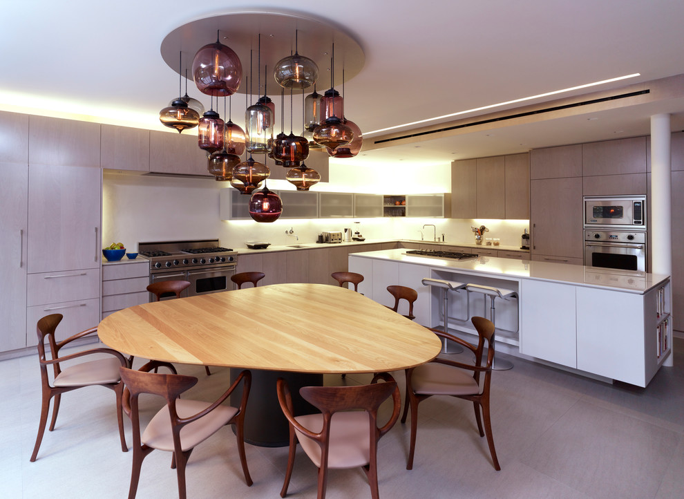 Immagine di una cucina abitabile minimal con ante lisce, ante in legno chiaro e elettrodomestici in acciaio inossidabile