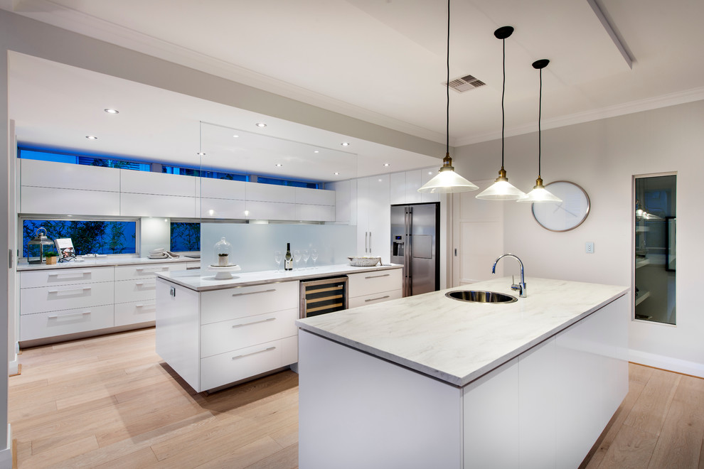 Moderne Küche mit flächenbündigen Schrankfronten, weißen Schränken, braunem Holzboden und zwei Kücheninseln in Perth
