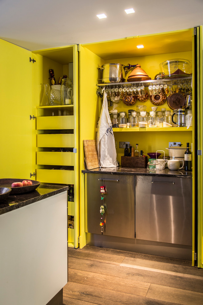Inredning av ett modernt kök, med öppna hyllor och gula skåp