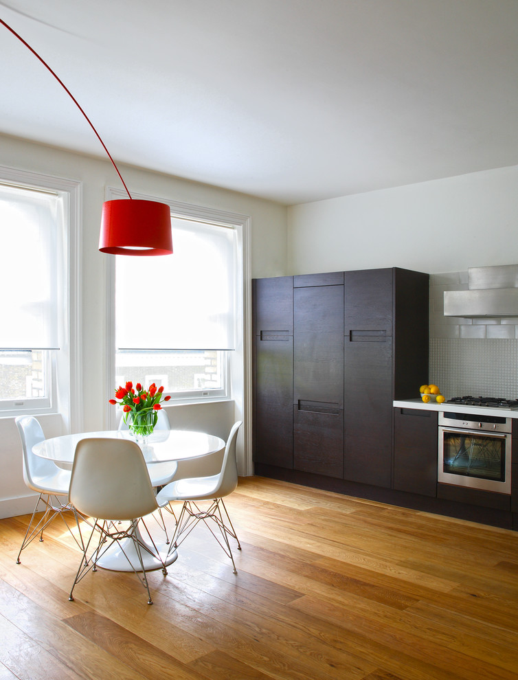 Свежая идея для дизайна: кухня в современном стиле с обеденным столом, плоскими фасадами и темными деревянными фасадами - отличное фото интерьера