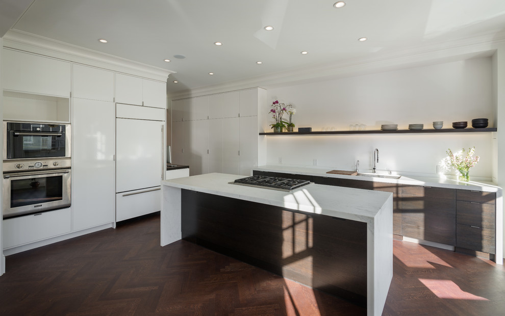 Ejemplo de cocina contemporánea con armarios con paneles lisos, puertas de armario blancas, encimera de mármol y electrodomésticos con paneles