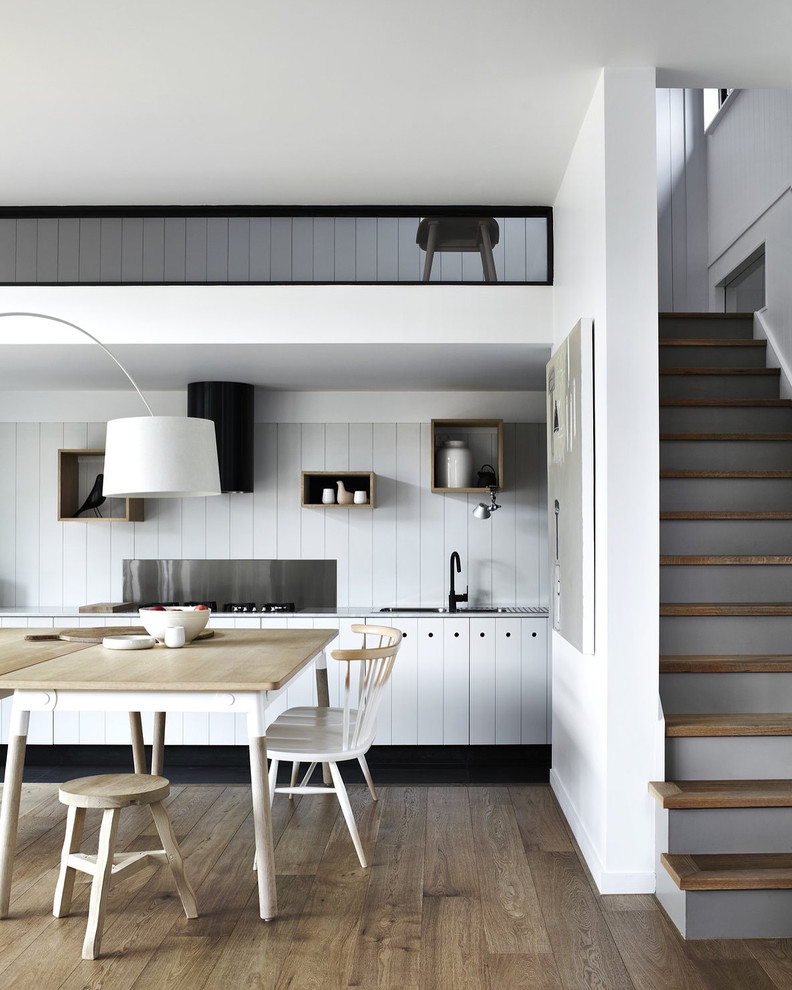 Einzeilige Moderne Wohnküche mit Einbauwaschbecken, weißen Schränken, Küchenrückwand in Weiß, braunem Holzboden, braunem Boden und weißer Arbeitsplatte in Melbourne