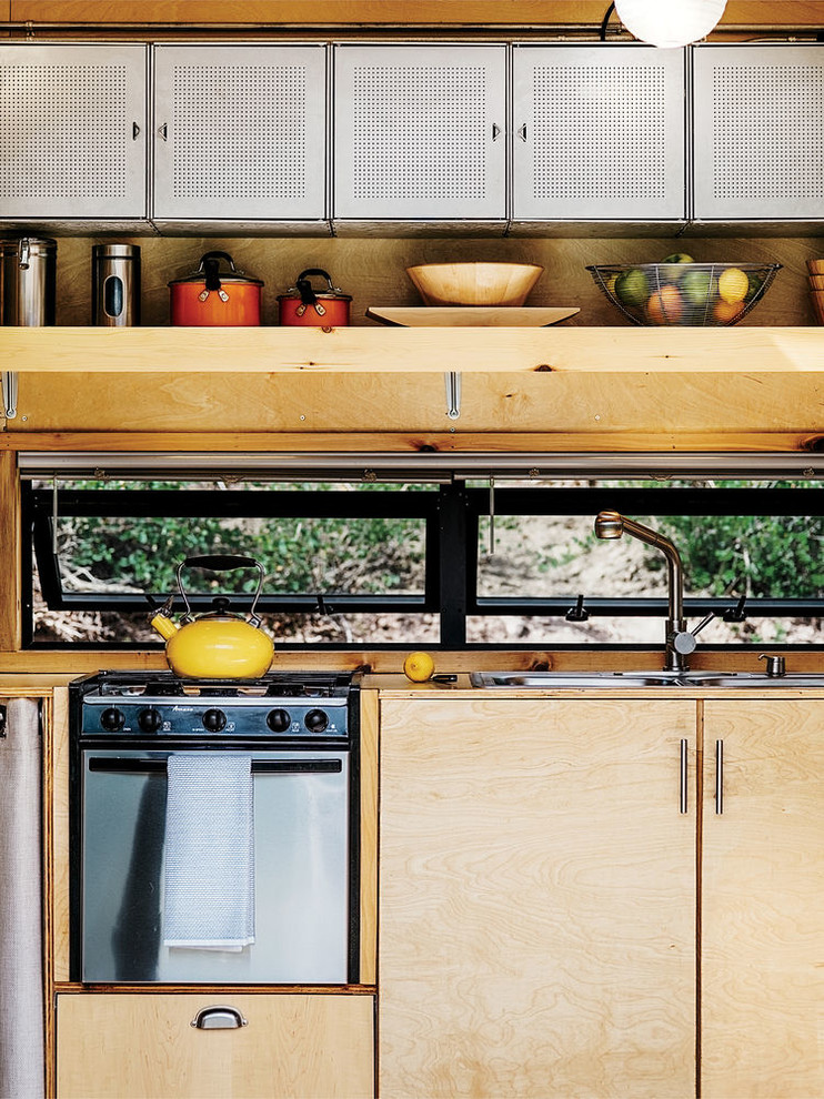 На фото: маленькая прямая кухня в современном стиле с накладной мойкой, плоскими фасадами и светлыми деревянными фасадами для на участке и в саду с