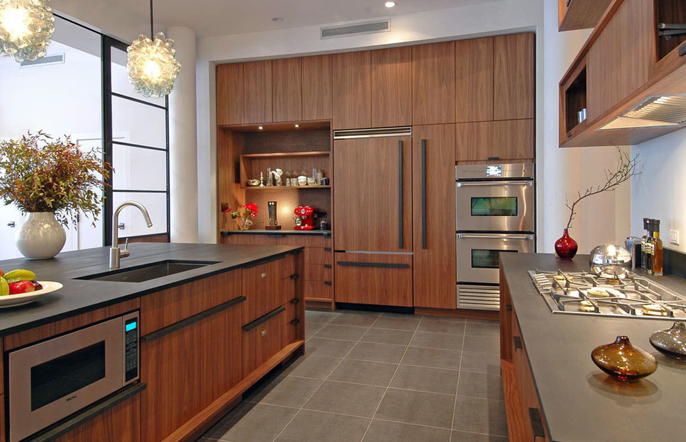 Moderne Küche mit Unterbauwaschbecken, flächenbündigen Schrankfronten, dunklen Holzschränken, Elektrogeräten mit Frontblende und Kücheninsel in Sonstige