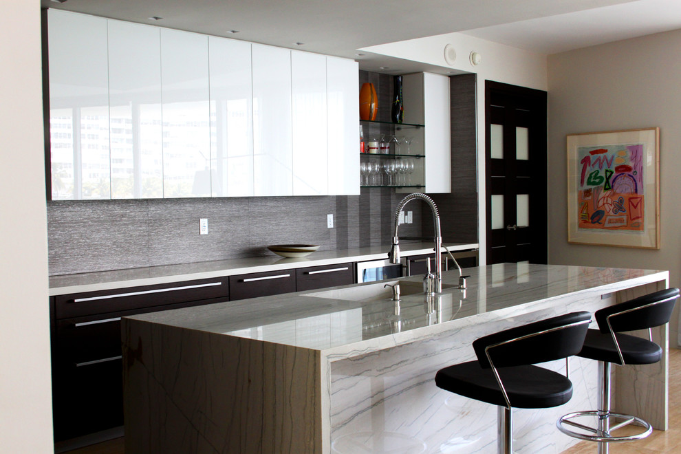 Esempio di una cucina minimal di medie dimensioni con ante nere, lavello sottopiano, ante lisce, top in marmo, elettrodomestici in acciaio inossidabile, parquet chiaro e pavimento marrone