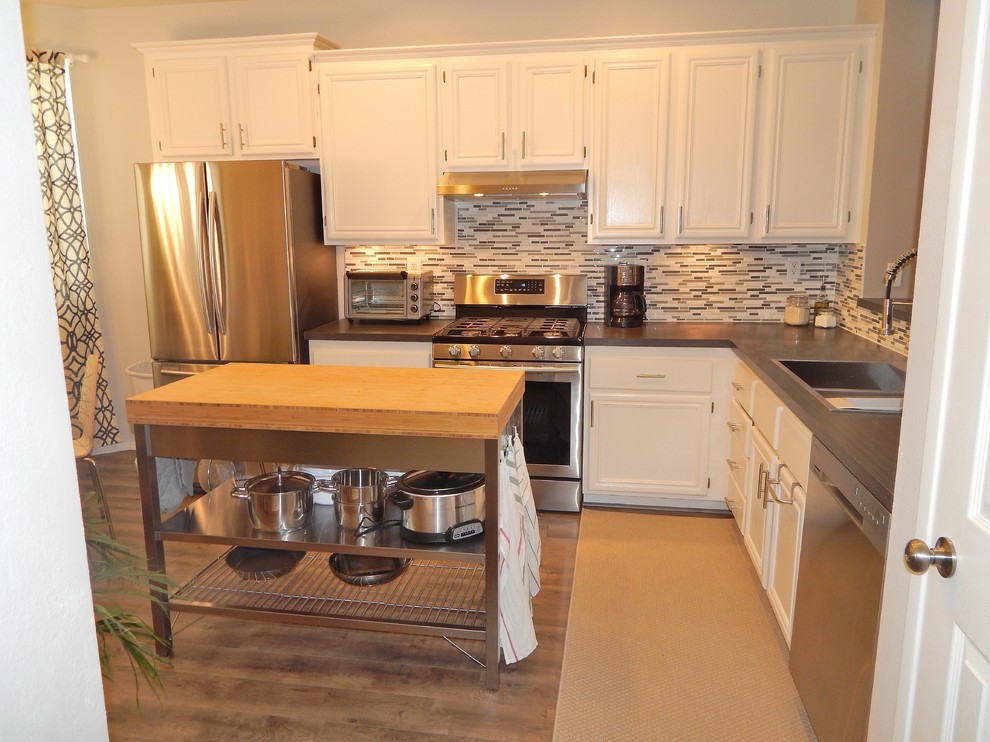 Exempel på ett avskilt, mellanstort modernt grå grått l-kök, med en nedsänkt diskho, luckor med infälld panel, vita skåp, laminatbänkskiva, flerfärgad stänkskydd, rostfria vitvaror, laminatgolv, grått golv, stänkskydd i mosaik och en köksö