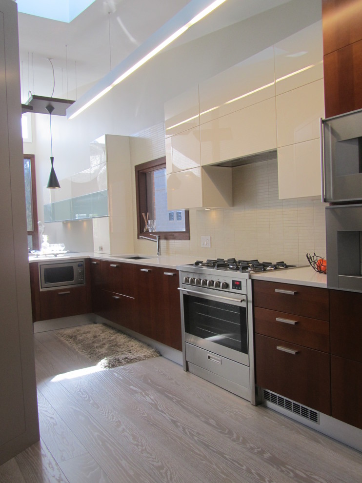Moderne Küche mit flächenbündigen Schrankfronten, weißen Schränken, Küchenrückwand in Weiß und Küchengeräten aus Edelstahl in Toronto