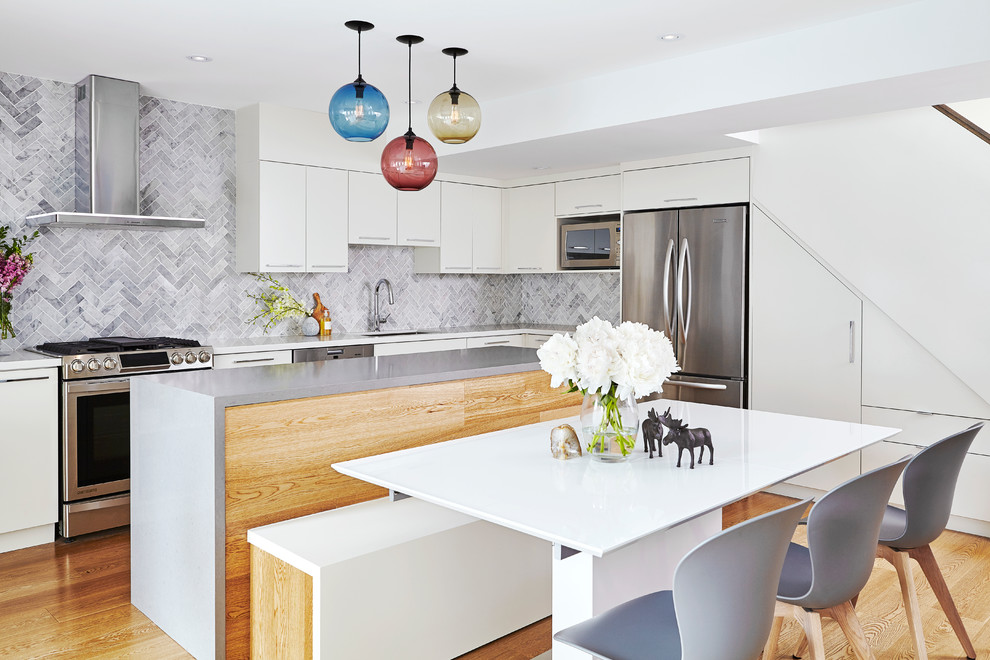 Inspiration for a contemporary medium tone wood floor kitchen remodel in Toronto with an undermount sink, flat-panel cabinets, white cabinets, gray backsplash, stainless steel appliances and an island