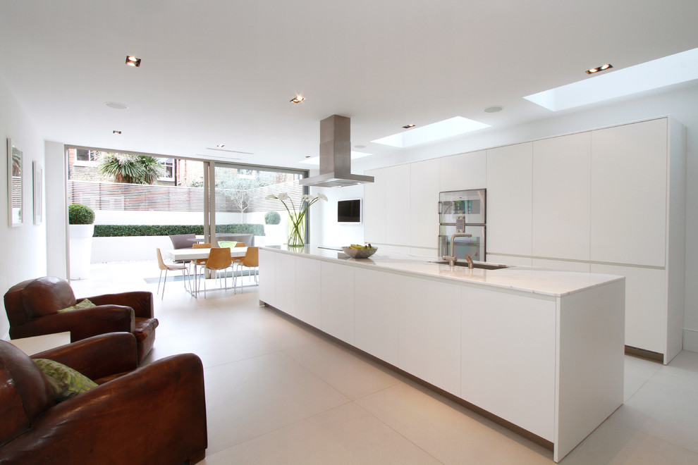 Zweizeilige, Große Moderne Wohnküche mit flächenbündigen Schrankfronten, weißen Schränken, Küchengeräten aus Edelstahl und Kücheninsel in London
