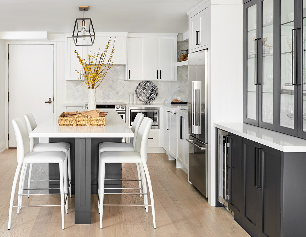 Immagine di una cucina chic con ante con riquadro incassato, ante grigie, paraspruzzi bianco, elettrodomestici in acciaio inossidabile, pavimento beige e top bianco