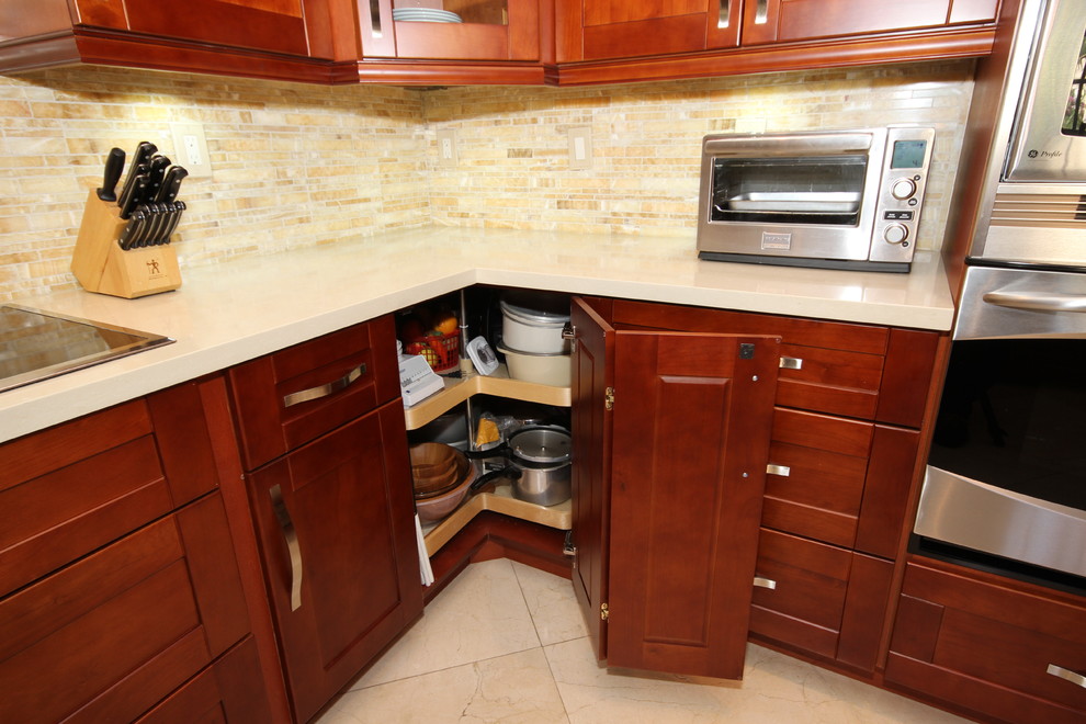Exemple d'une cuisine tendance en U et bois brun fermée avec un évier encastré, un placard à porte shaker, un plan de travail en quartz, une crédence beige et un électroménager en acier inoxydable.
