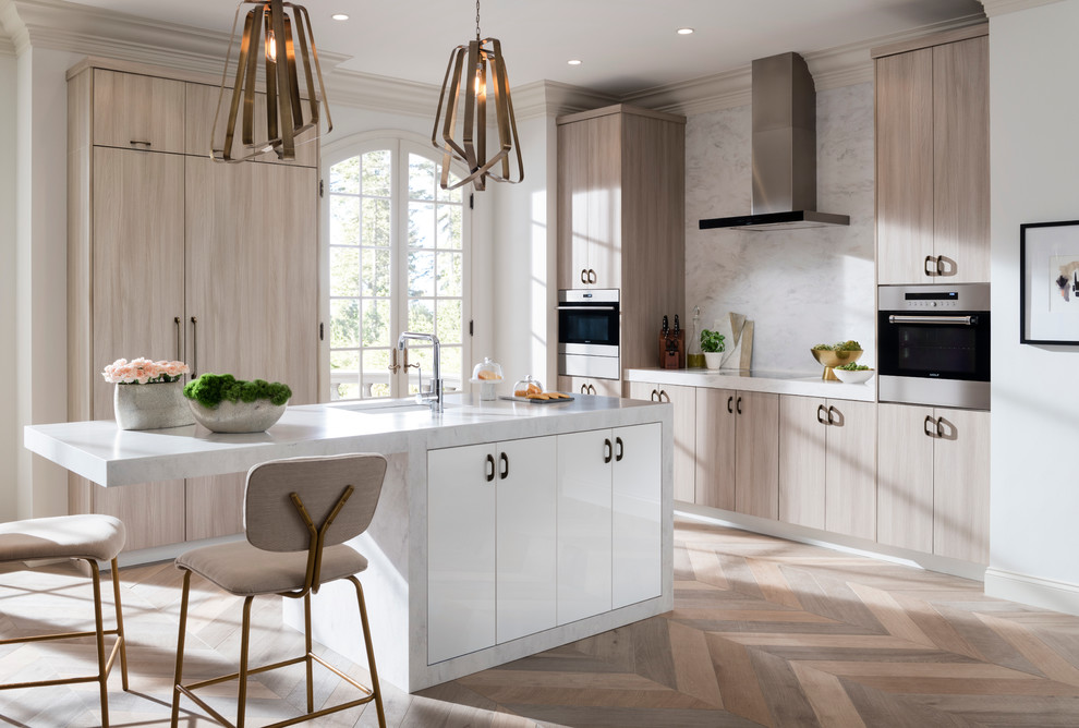 Mid-sized trendy l-shaped medium tone wood floor and brown floor eat-in kitchen photo in Raleigh with flat-panel cabinets, light wood cabinets, white backsplash, stainless steel appliances, an island, solid surface countertops and an undermount sink