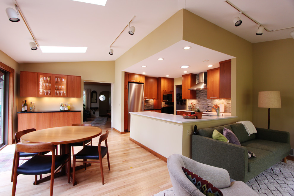 Exempel på ett litet modernt kök, med en undermonterad diskho, släta luckor, skåp i mellenmörkt trä, bänkskiva i kvarts, flerfärgad stänkskydd, stänkskydd i glaskakel, rostfria vitvaror, ljust trägolv och en halv köksö