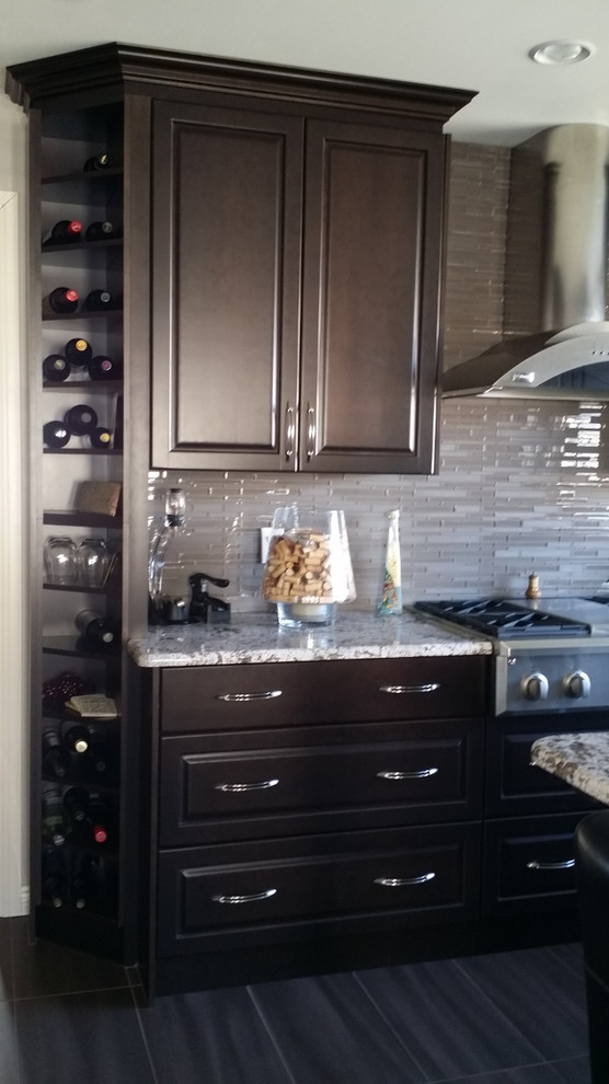 Inredning av ett modernt mellanstort kök, med en undermonterad diskho, luckor med upphöjd panel, skåp i mörkt trä, granitbänkskiva, beige stänkskydd, stänkskydd i stickkakel, rostfria vitvaror, klinkergolv i porslin, en köksö och svart golv