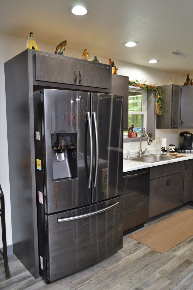 На фото: угловая кухня-гостиная среднего размера в современном стиле с накладной мойкой, плоскими фасадами, серыми фасадами, столешницей из ламината, полом из ламината, островом, серым полом и желтой столешницей