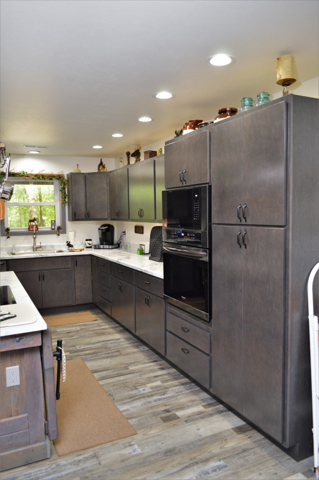 Modern inredning av ett mellanstort gul gult kök, med en nedsänkt diskho, släta luckor, grå skåp, laminatbänkskiva, laminatgolv, en köksö och grått golv