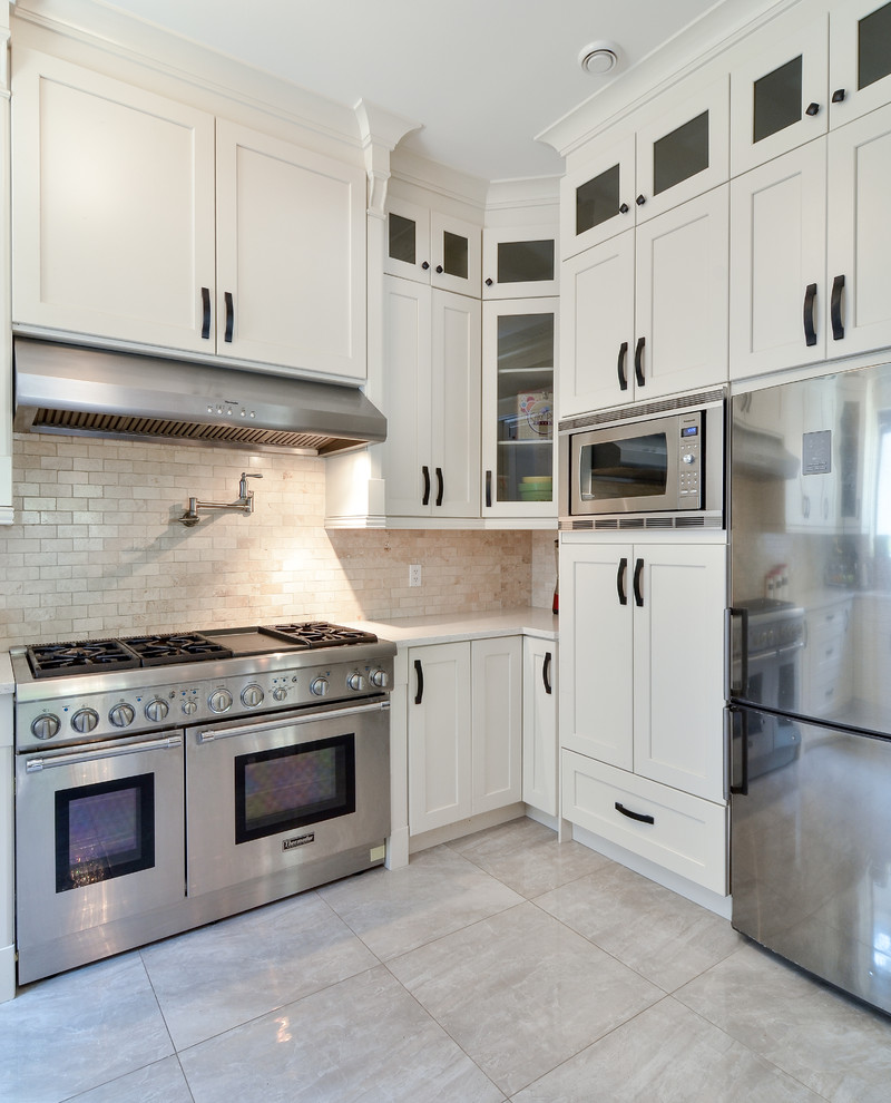 Foto di una grande cucina minimalista con ante in stile shaker, ante bianche, top in quarzite, elettrodomestici in acciaio inossidabile, paraspruzzi beige e paraspruzzi in lastra di pietra