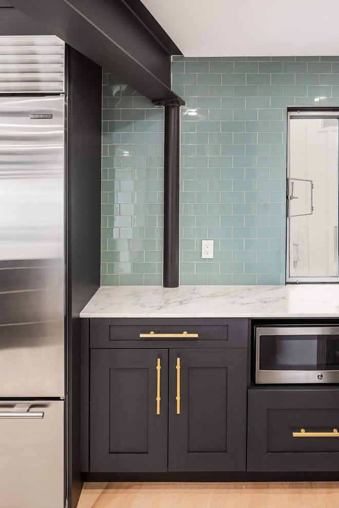 Idéer för ett stort modernt vit kök, med en undermonterad diskho, luckor med infälld panel, svarta skåp, marmorbänkskiva, grönt stänkskydd, stänkskydd i glaskakel, rostfria vitvaror, ljust trägolv, en köksö och brunt golv