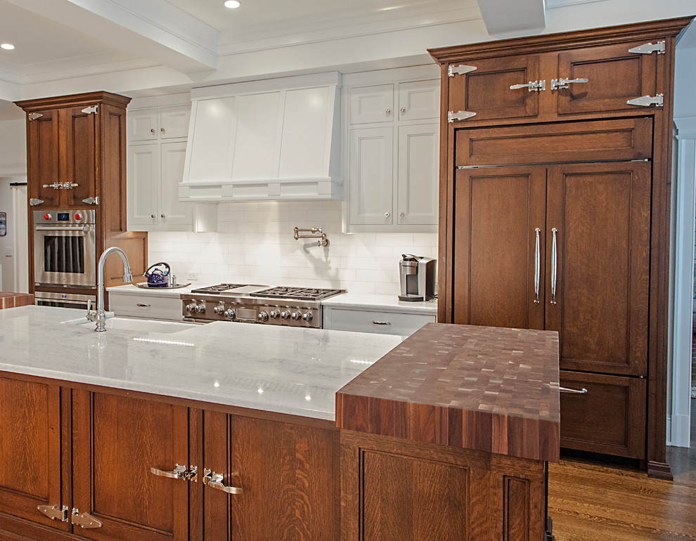 Example of a huge trendy single-wall painted wood floor and brown floor open concept kitchen design in New York with raised-panel cabinets, brown cabinets, granite countertops, white appliances, an island, a farmhouse sink, white backsplash, ceramic backsplash and white countertops