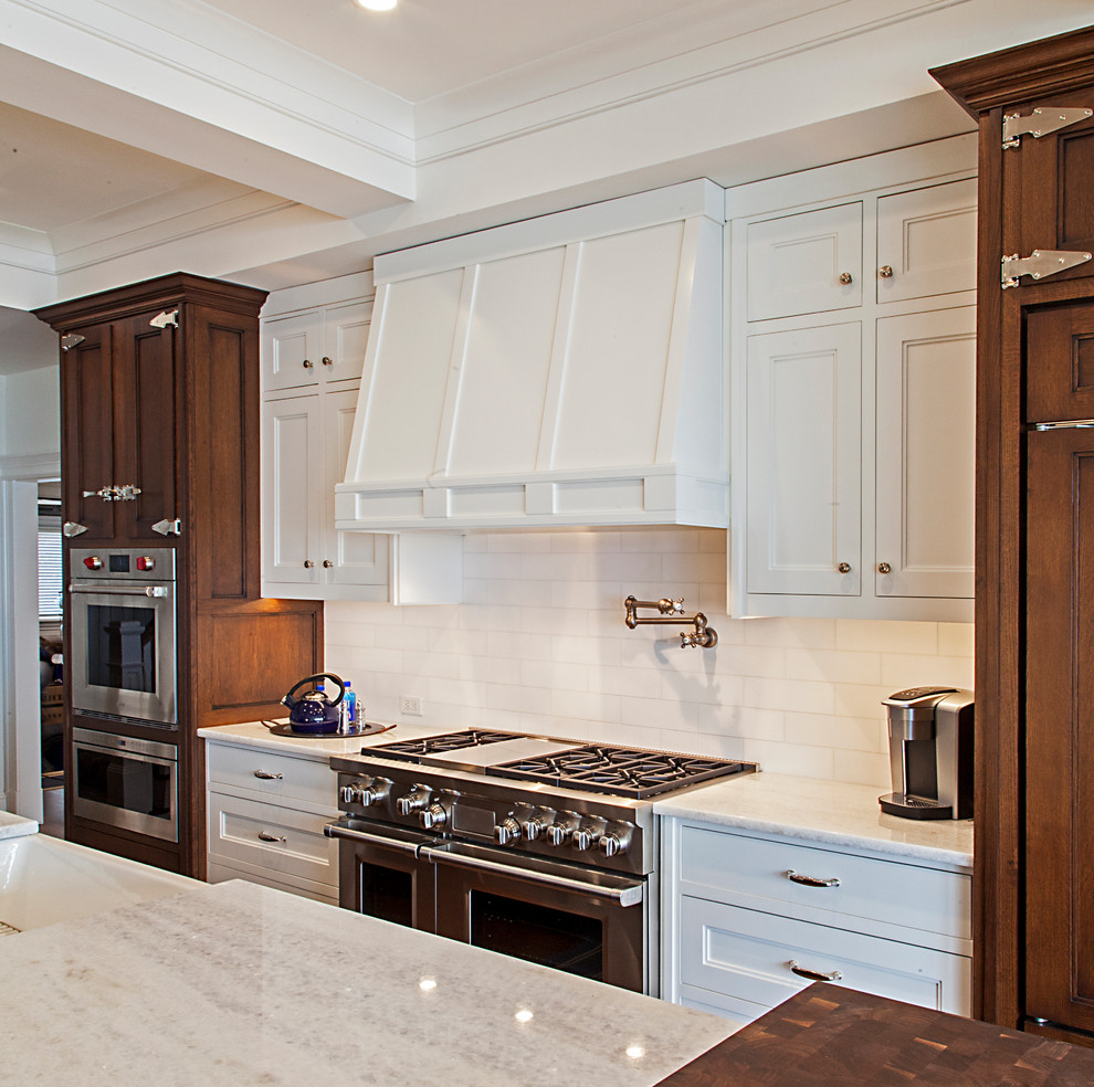 Inredning av ett modernt mycket stort vit linjärt vitt kök med öppen planlösning, med luckor med upphöjd panel, bruna skåp, granitbänkskiva, vita vitvaror, en köksö, vitt stänkskydd, stänkskydd i keramik, målat trägolv, brunt golv och en rustik diskho