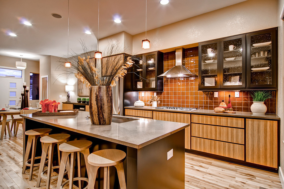 Стильный дизайн: кухня в современном стиле с обеденным столом, врезной мойкой, стеклянными фасадами, оранжевым фартуком и техникой из нержавеющей стали - последний тренд