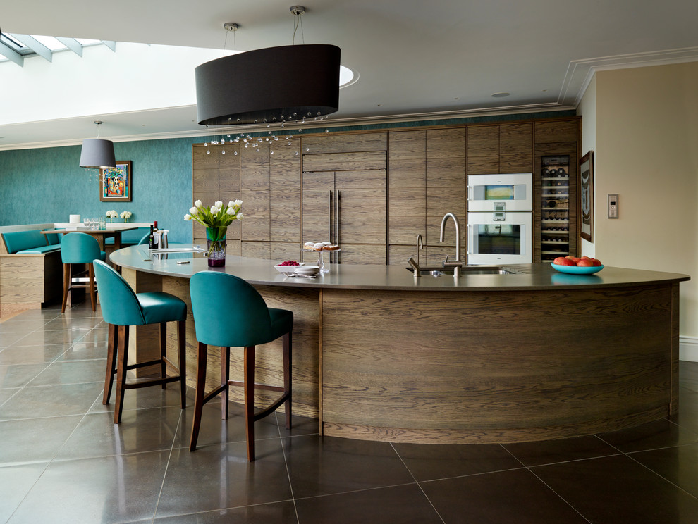 Cette photo montre une très grande cuisine ouverte encastrable tendance en bois foncé avec un placard à porte plane, îlot et un plan de travail en surface solide.