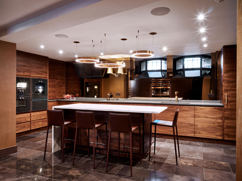 Photo of a contemporary u-shaped enclosed kitchen in London with a submerged sink, flat-panel cabinets, medium wood cabinets, mirror splashback, black appliances, an island, multi-coloured floors and multicoloured worktops.