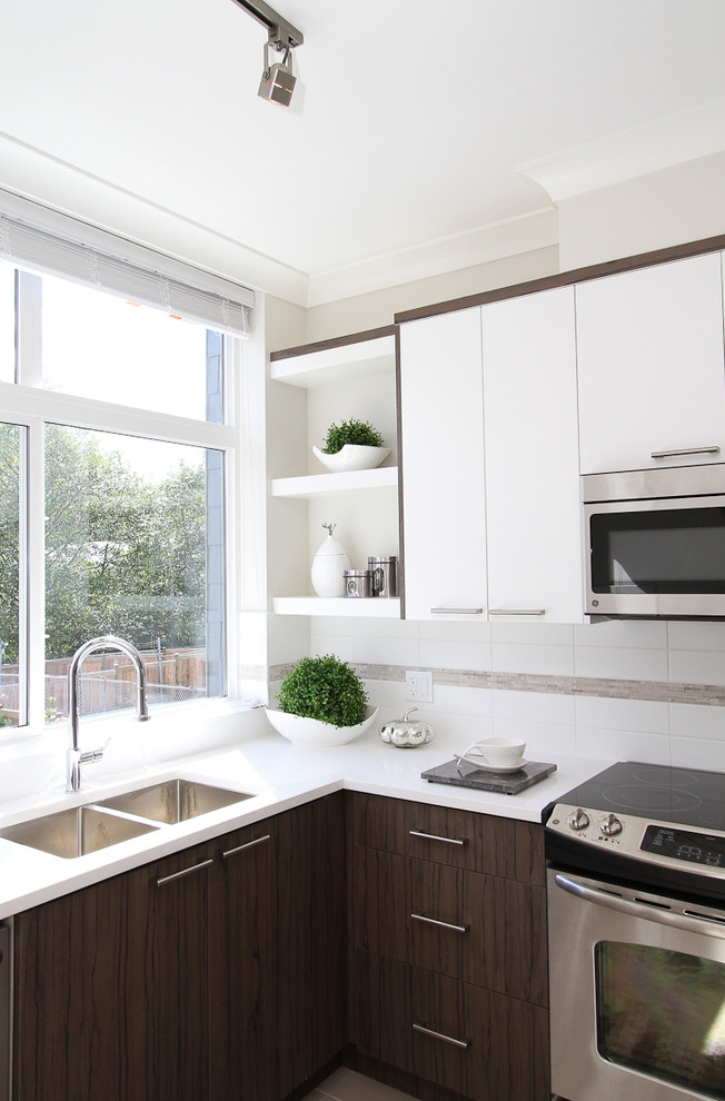 Design ideas for a medium sized contemporary l-shaped kitchen in Vancouver with a built-in sink, flat-panel cabinets, white cabinets, engineered stone countertops, white splashback, stainless steel appliances and ceramic flooring.