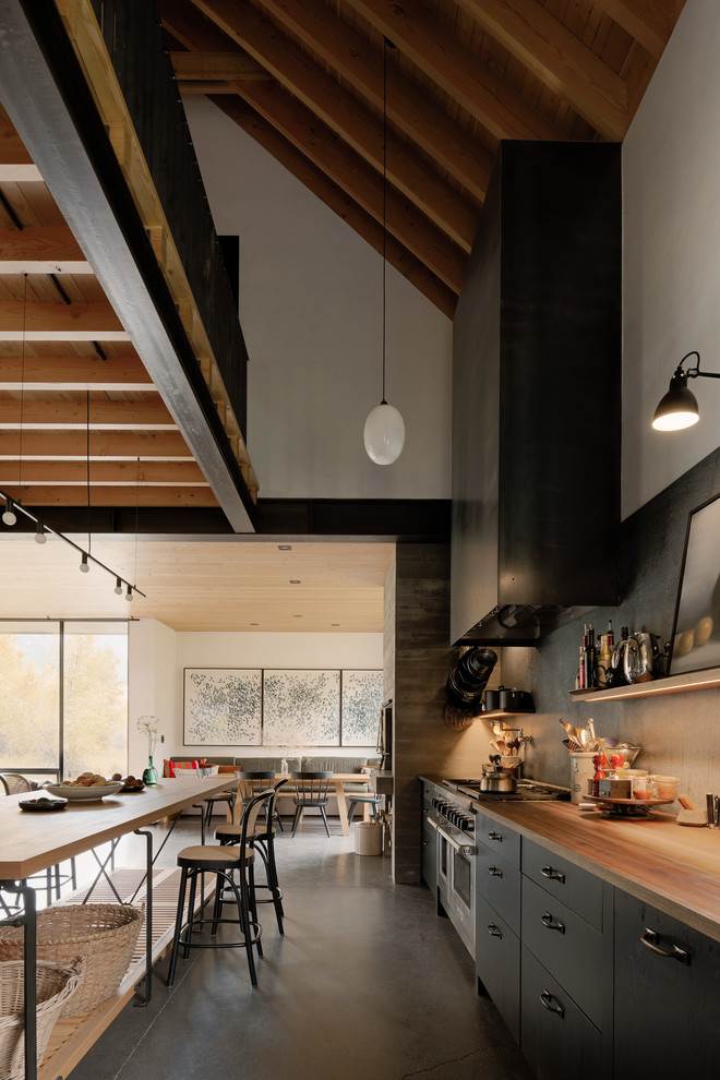 Idéer för ett modernt kök och matrum, med träbänkskiva, rostfria vitvaror och betonggolv