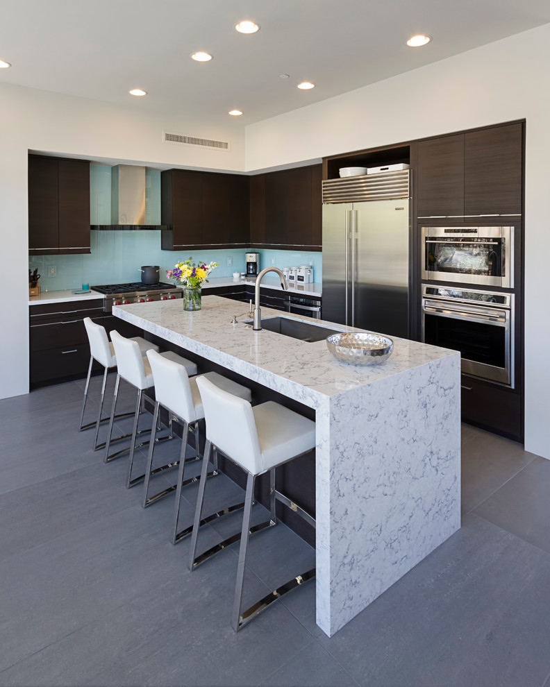 Open concept kitchen - mid-sized contemporary l-shaped open concept kitchen idea in Phoenix with flat-panel cabinets, dark wood cabinets, quartz countertops, blue backsplash, glass sheet backsplash, stainless steel appliances and an island
