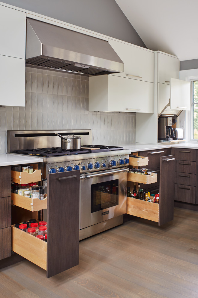Expansive contemporary l-shaped kitchen/diner in Boston with a belfast sink, light hardwood flooring and multiple islands.
