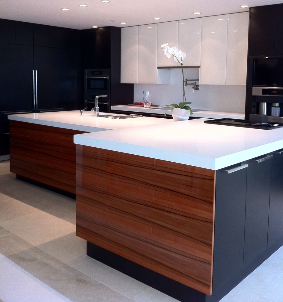 This is an example of a medium sized contemporary u-shaped kitchen/diner in Miami with flat-panel cabinets, white splashback, stainless steel appliances, an island, black cabinets, engineered stone countertops and stone slab splashback.