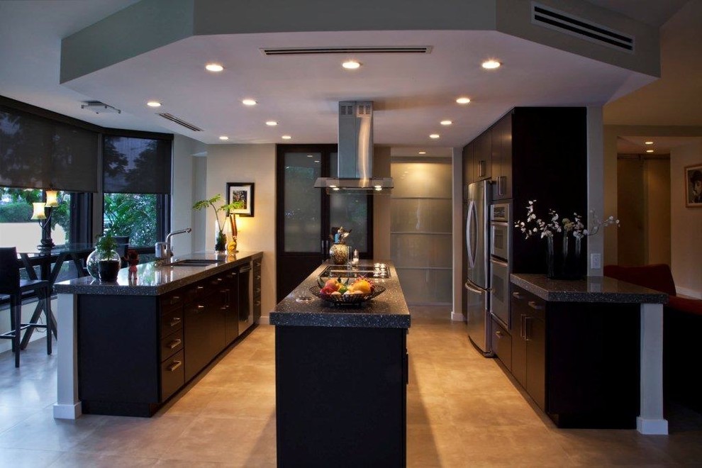 Photo of a large contemporary l-shaped kitchen/diner in Miami with a double-bowl sink, flat-panel cabinets, dark wood cabinets, engineered stone countertops, stainless steel appliances, ceramic flooring, an island and brown floors.