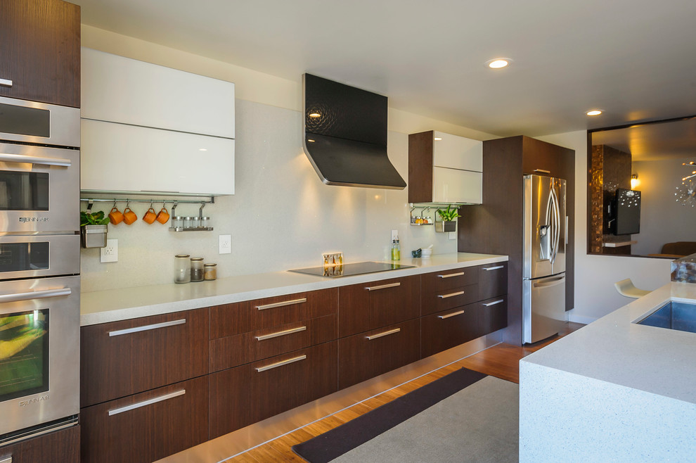 Inspiration for a contemporary u-shaped eat-in kitchen remodel in San Francisco with an undermount sink, brown cabinets, quartz countertops, white backsplash, stone slab backsplash and stainless steel appliances