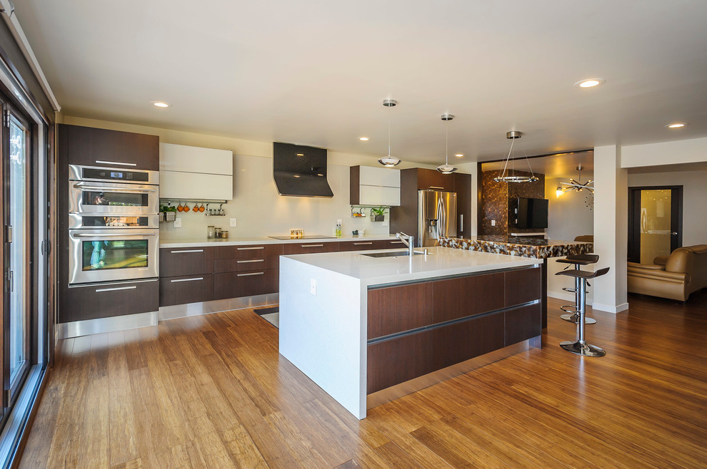 Example of a trendy u-shaped eat-in kitchen design in San Francisco with an undermount sink, brown cabinets, quartz countertops, white backsplash, stone slab backsplash and stainless steel appliances