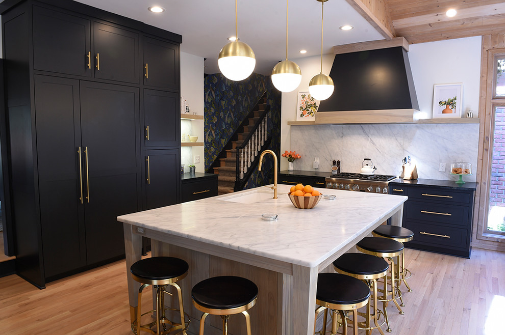 Inspiration for a large contemporary light wood floor and beige floor kitchen remodel in Cleveland with an undermount sink, shaker cabinets, black cabinets, white backsplash, an island, quartz countertops, stone slab backsplash and paneled appliances