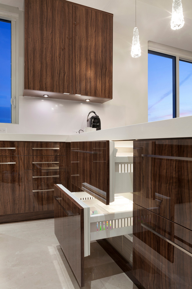 Design ideas for a large contemporary l-shaped enclosed kitchen in Miami with flat-panel cabinets, dark wood cabinets, composite countertops, black appliances, ceramic flooring, no island, beige floors and white worktops.