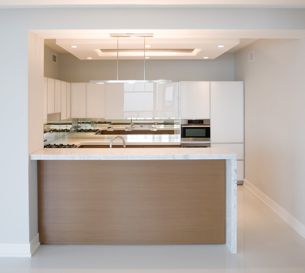 Example of a small trendy u-shaped eat-in kitchen design in Chicago with an undermount sink, flat-panel cabinets, white cabinets, marble countertops, metal backsplash, stainless steel appliances and a peninsula
