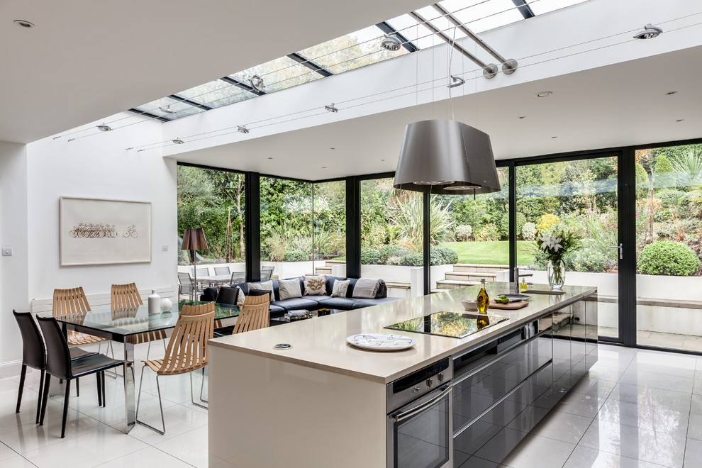 Offene Moderne Küche mit flächenbündigen Schrankfronten, grauen Schränken, Küchengeräten aus Edelstahl und Kücheninsel in Surrey