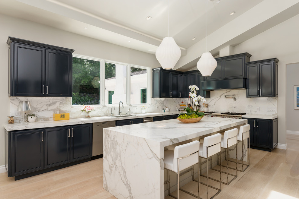 Inspiration for a traditional kitchen in San Francisco with a submerged sink, recessed-panel cabinets, blue cabinets, marble worktops, white splashback, marble splashback, stainless steel appliances, light hardwood flooring, an island and beige floors.
