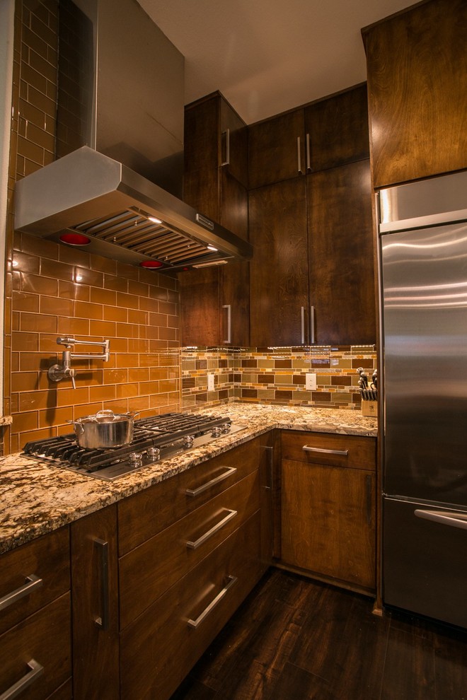 Bild på ett stort funkis kök, med en undermonterad diskho, släta luckor, skåp i mellenmörkt trä, granitbänkskiva, brunt stänkskydd, stänkskydd i glaskakel, rostfria vitvaror, vinylgolv och en köksö